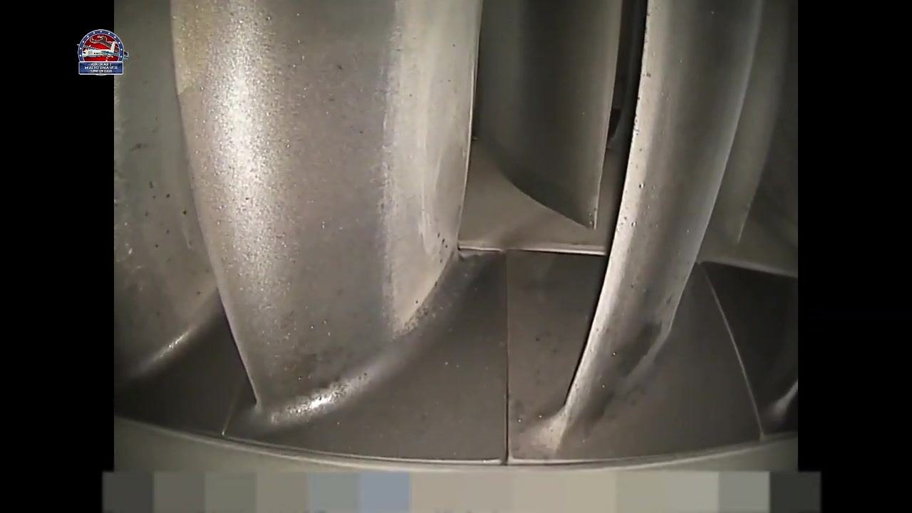 Wide-angle view of several turbine blades, most appearing smooth with minor surface speckling