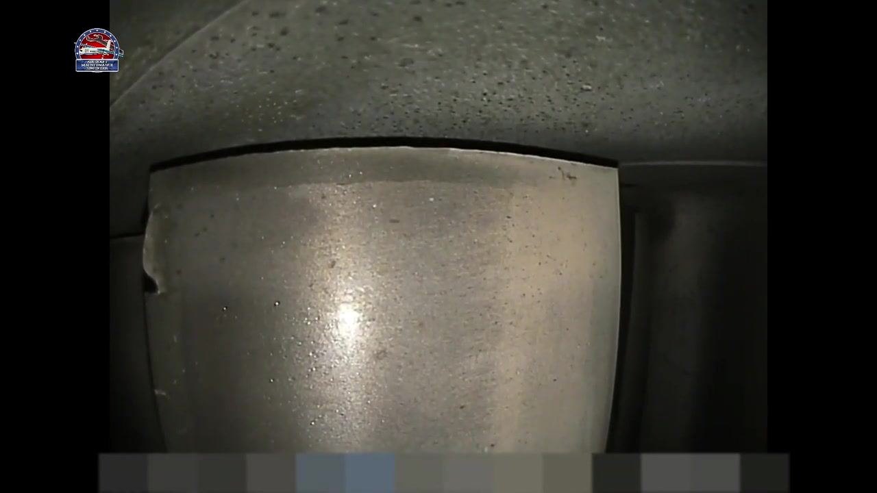 Metallic component showing the visible chip and crack on the left edge from a confirming angle