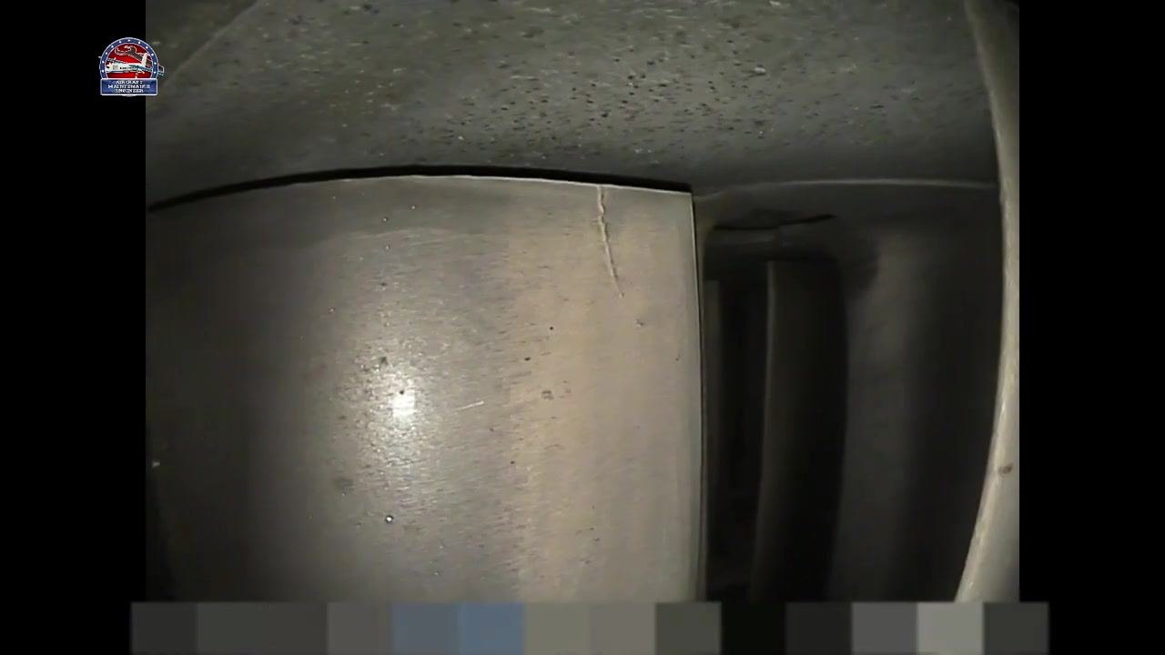 Metallic component with a visible crack at the top edge and an adjacent blade partially in view