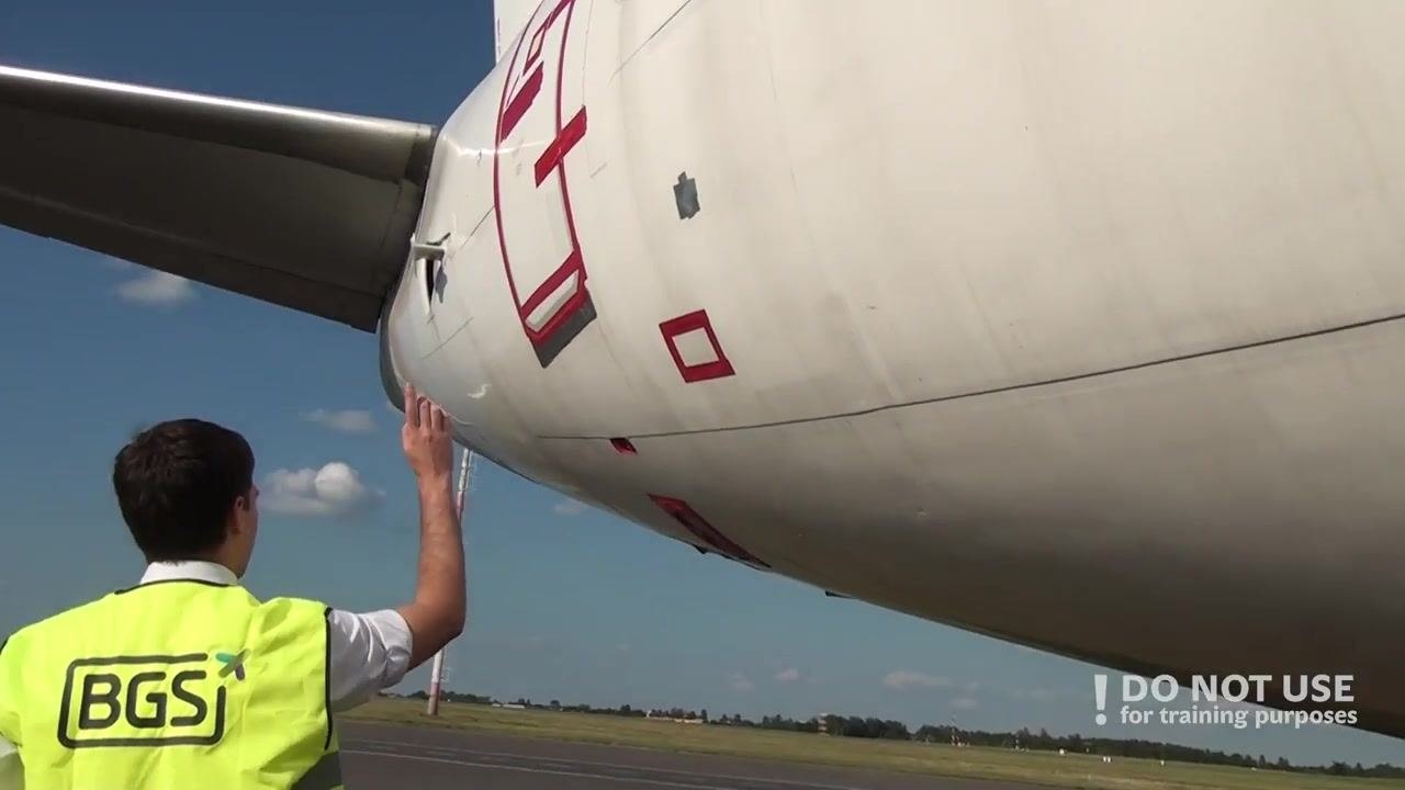 Person inspecting the lower aft fuselage, focusing on the negative pressure relief valve and aircraft markings.