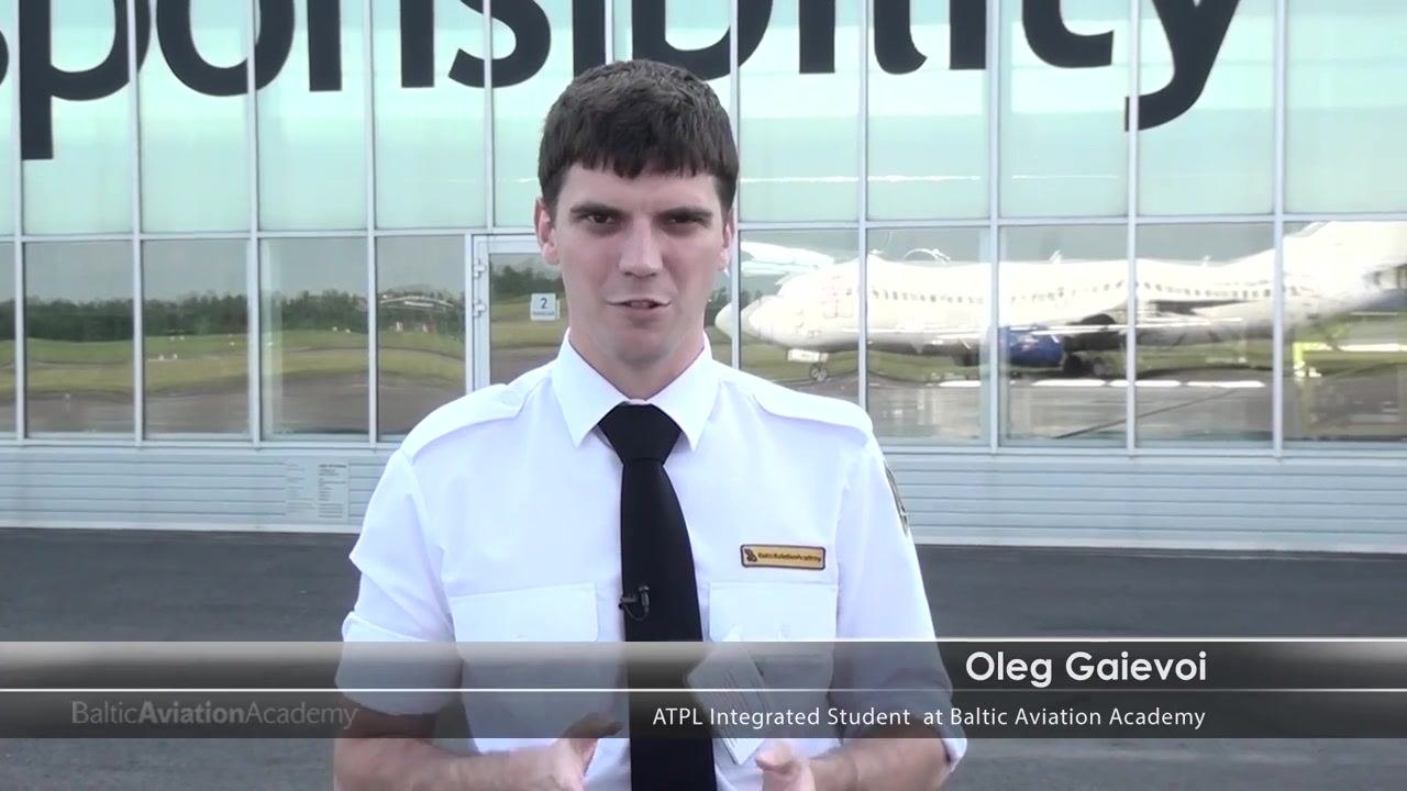 A person in a white pilot shirt and black tie stands in front of a glass building with the reflection of a 737. The text overlay reads "Oleg Gaievoi, ATPL Integrated Student at Baltic Aviation Academy".