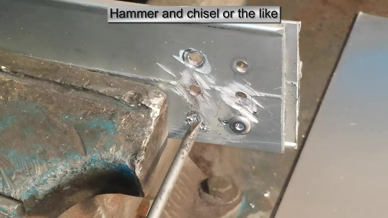 A chisel or screwdriver inserted into the rivet hole to remove remaining metal debris. On-screen text: "Hammer and chisel or the like."