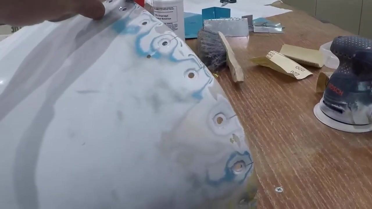 A close-up view of the attachment holes and stop-drilled cracks at the end of the tail cone shows sanded and prepped surfaces, with tools and sanding equipment visible on the workbench.