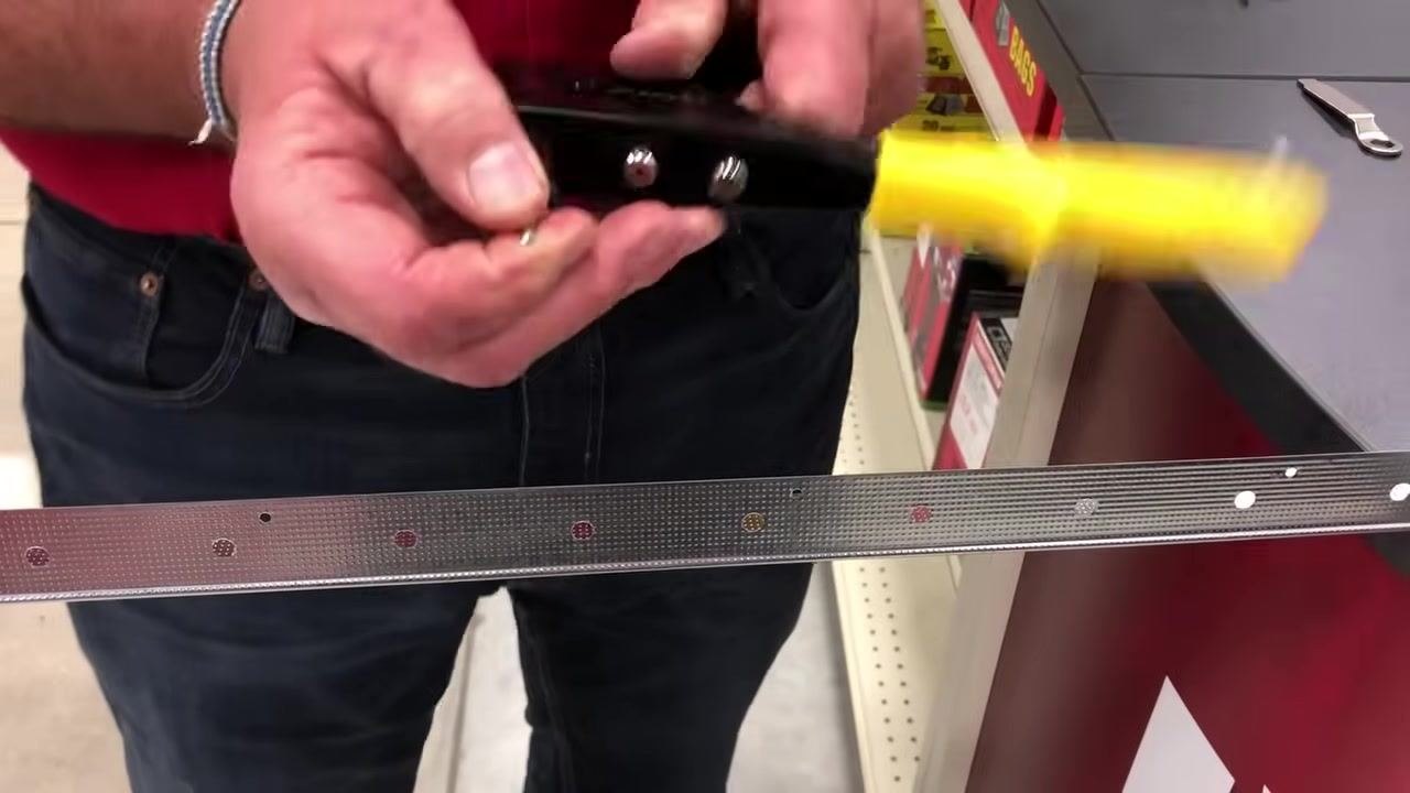 Metal corner bead with pre-drilled holes held in a hardware store aisle