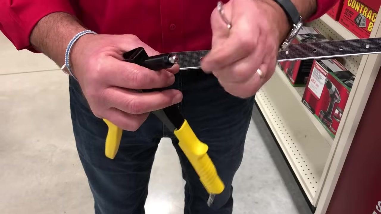 New tip being screwed onto the rivet gun, close-up on hands and tool