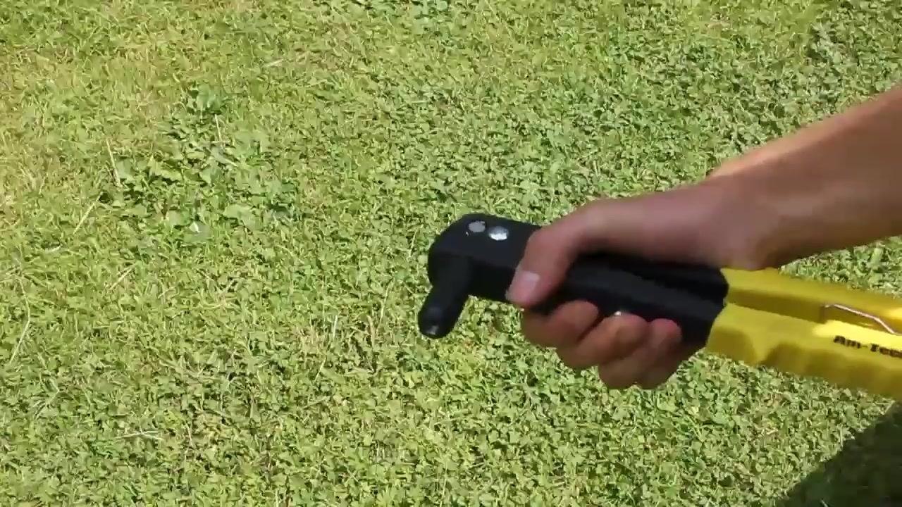 The user holding the riveter with the handle pulled in, preparing to insert the new nozzle.