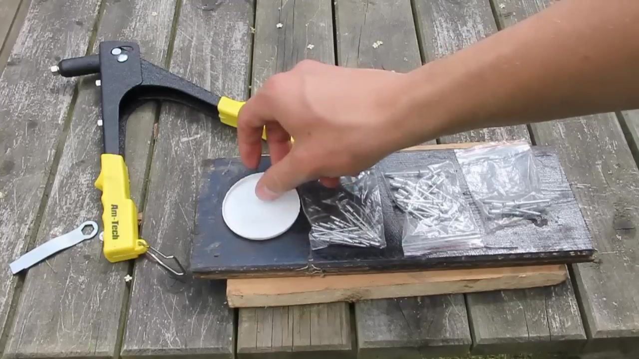The user positioning the drill near the stacked plastic and wood materials, ready to drill through them.