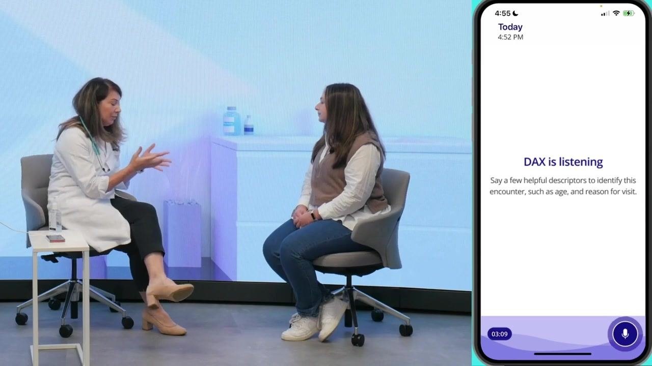 Provider and patient seated in a clinical setting, with the DAX app displaying "DAX is listening" and instructions to say descriptors for the encounter