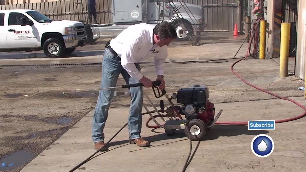 A close-up of the spray gun and test gauge shows the pressure reading with a hand on the trigger.