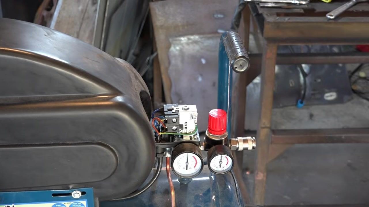 Hand turning the adjustment screw counterclockwise to decrease pressure, with the screw and markings in close-up