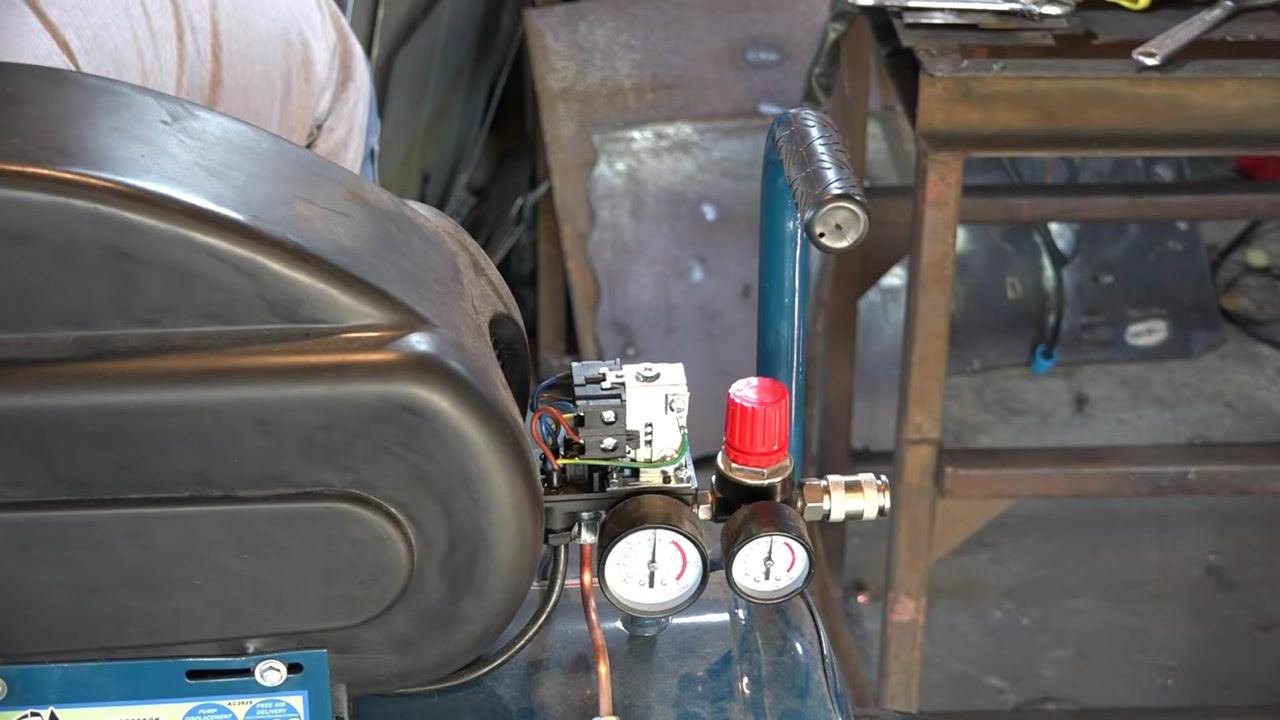 Hand and screwdriver turning the adjustment screw as spring tension is reduced