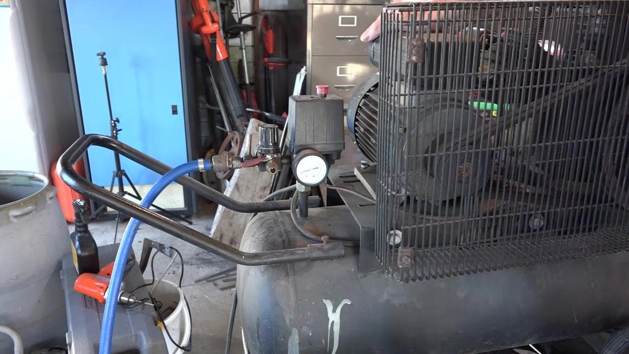 Close-up of the compressor pressure gauge with a finger pointing at the needle near 60–65 psi