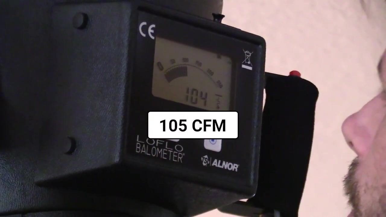 Close-up of the flow hood display showing a reading of 104 CFM as the damper is partially reopened.