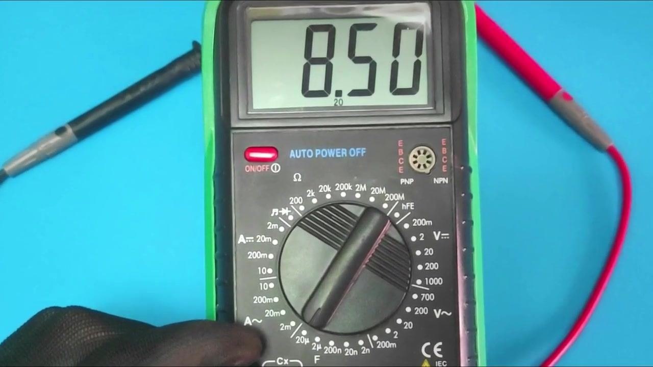 A 9V battery connected to a capacitor with red and black jumper wires attached to the correct terminals, ready for voltage testing.