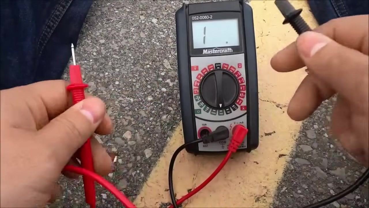 Hands hold the test leads, ready to test another component with the multimeter set up for further continuity checks.