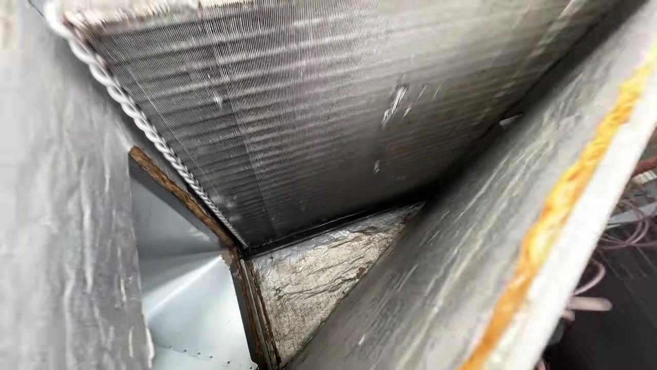 A wide view shows the open Goodman HVAC unit, the Port-A-Blaster cleaning machine, the water bucket, and tools in an outdoor setting.