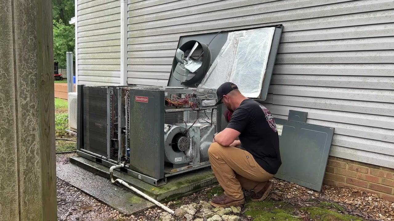 A technician gestures toward the cleaned condenser coil and cleaning equipment, confirming that cleaning is complete.