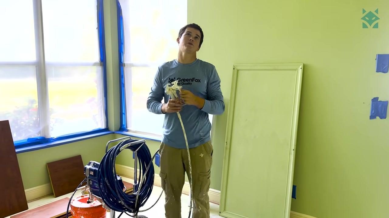 A technician operates the whip tool inside an open ceiling duct to agitate and loosen dust.