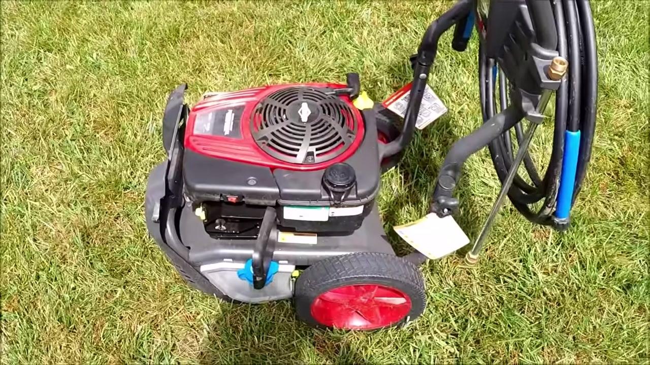 Close-up of the air filter compartment with the green foam air filter visible, along with the blue detergent cap and some dirt.