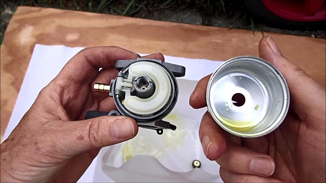 Close-up of the carburetor and float bowl, both appearing clean, with the float mechanism and brass jet visible.