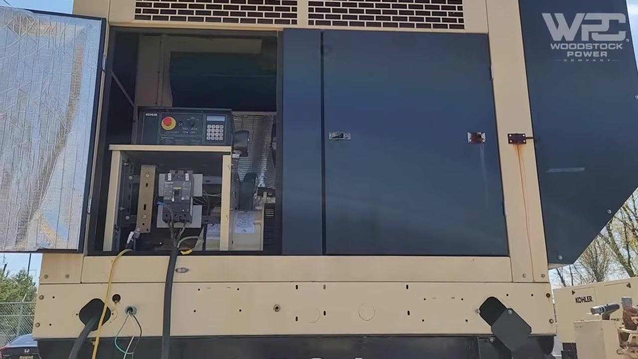 Technician using a clamp meter to measure current on a red phase lead, with the meter display showing 31.7 amps