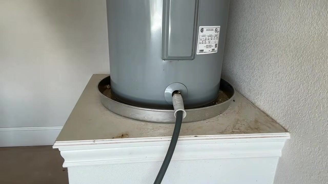 Water heater with hose attached, draining after a repeated flush, no person visible