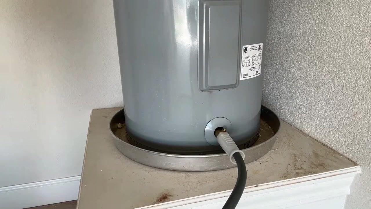 Garden hose securely attached to the water heater drain valve, ready for draining