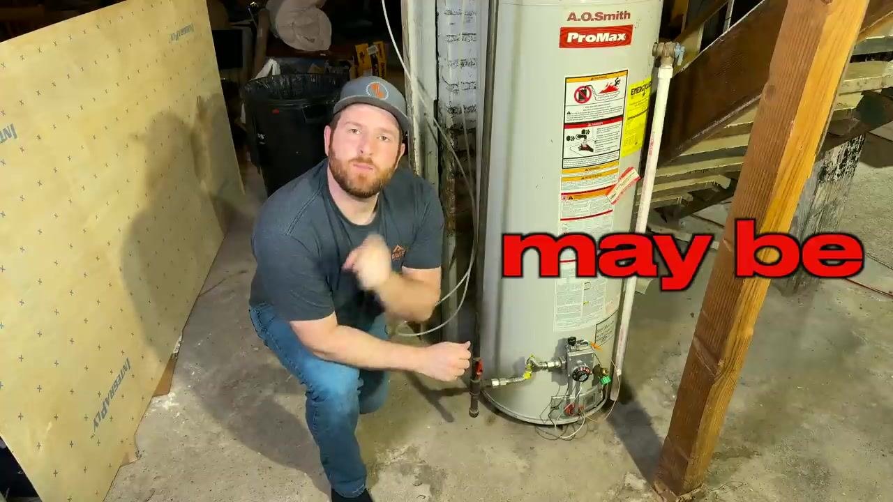 Person in a basement next to an A.O. Smith ProMax water heater, preparing to begin the flushing process.