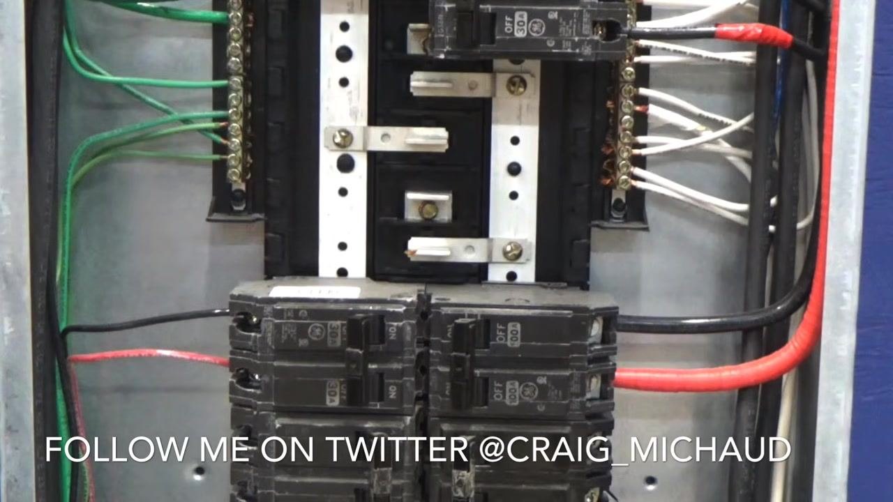 Close-up of an open electrical panel showing multiple circuit breakers, the neutral and ground bars, and neatly routed wires.