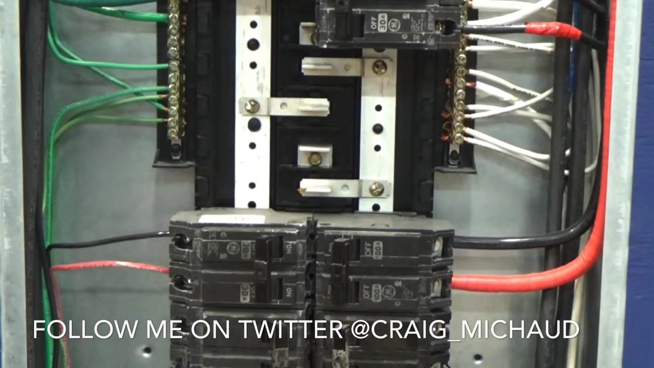 Close-up of the electrical panel showing the neutral bar, available breaker slots, and wiring. Text overlay: "FOLLOW ME ON TWITTER @CRAIG_MICHAUD".