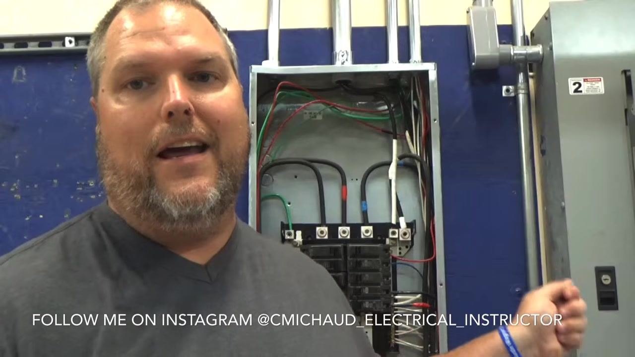 Instructor explaining the need to locate the correct neutral wire in the panel, gesturing toward the wiring.