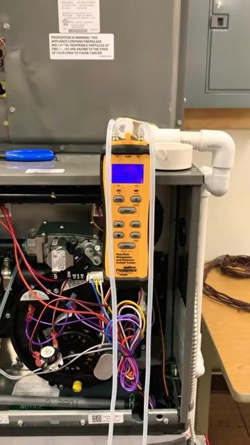 Close-up of the manometer now displaying the return static pressure reading, with the display showing a value around 0.03 to 0.04 inches.