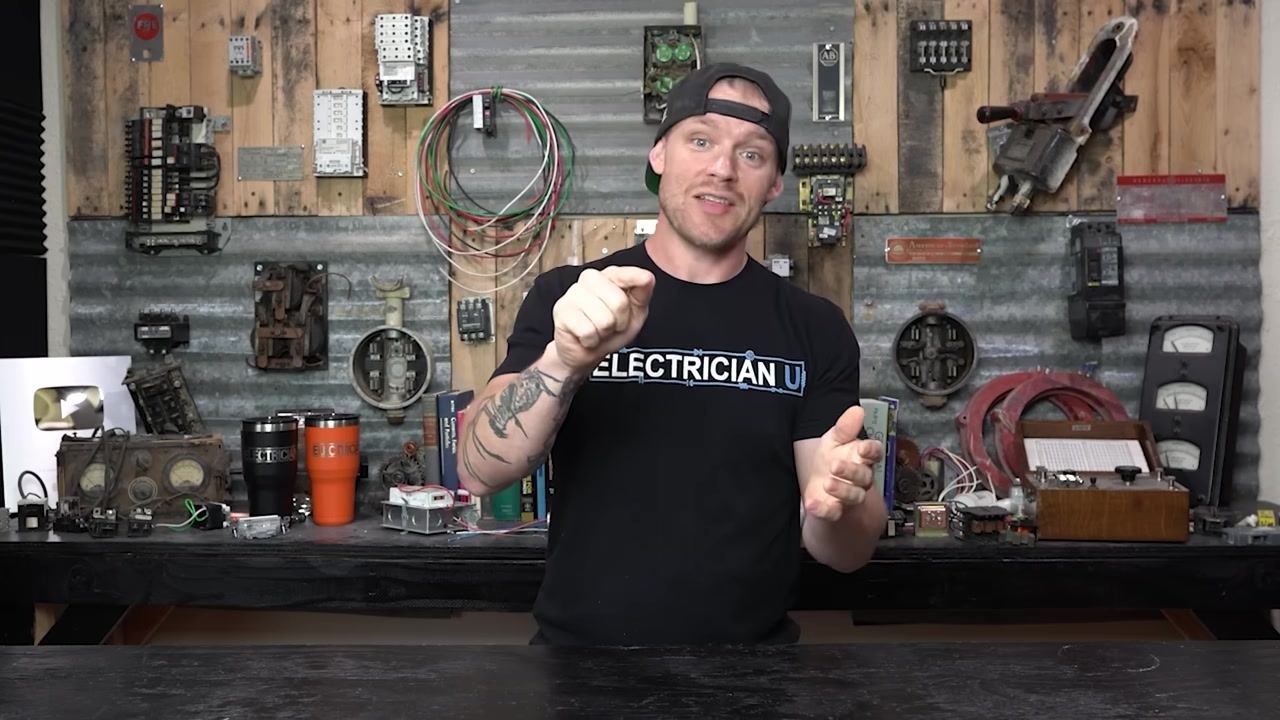 Presenter mimicking pressing a test button, highlighting the need to verify breaker functionality