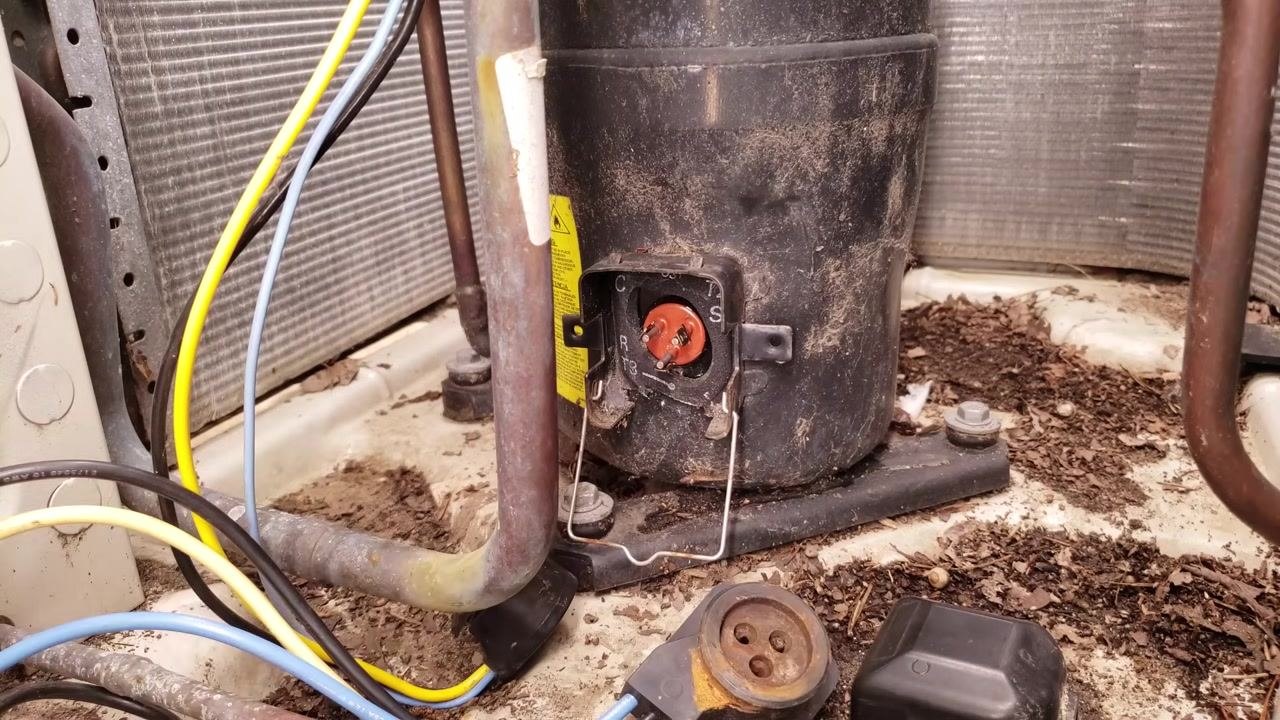 Compressor plug area with exposed terminals as the technician prepares for the next diagnostic step