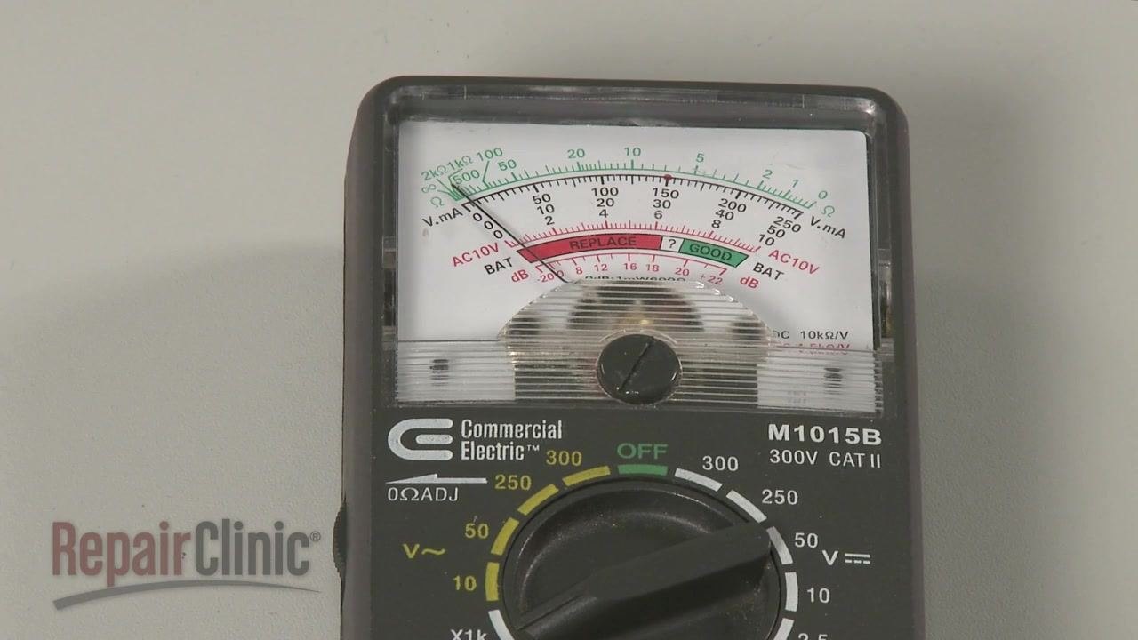 Analog ohm meter showing needle movement during a dual capacitor test