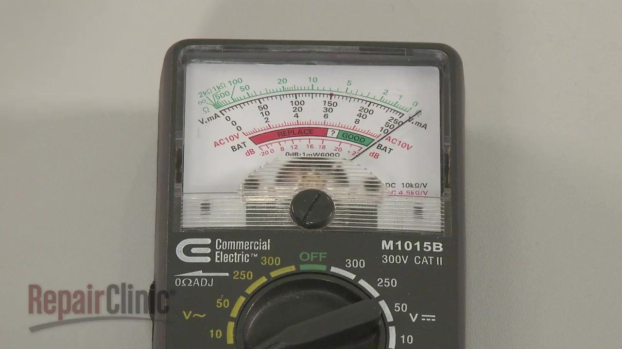 Hand using an insulated screwdriver to discharge a capacitor, with a "SHOCK" warning icon visible