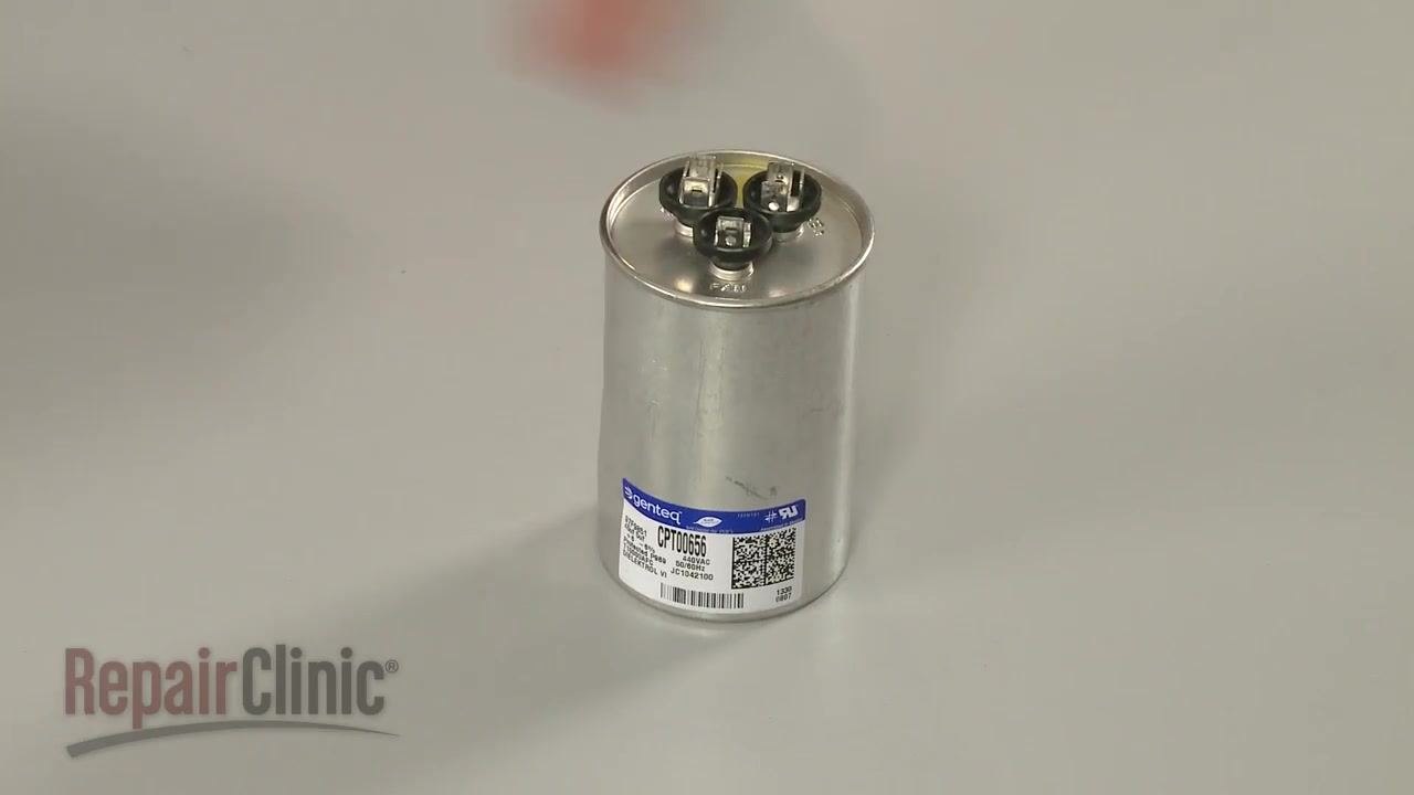 Hand holding a single capacitor labeled "7.5 MFD 370 VAC", showing the microfarad rating clearly