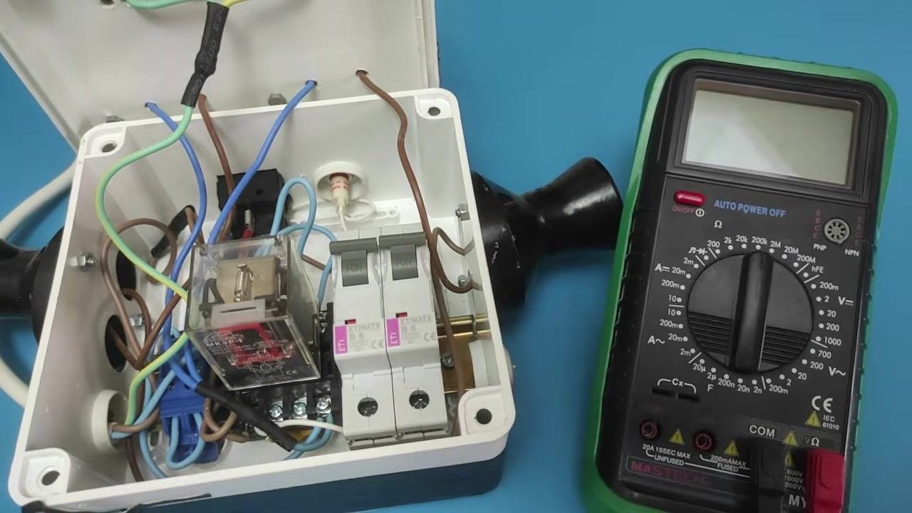 Multimeter placed next to an open circuit breaker box, dial set to the ohms (Ω) setting, ready for measurement