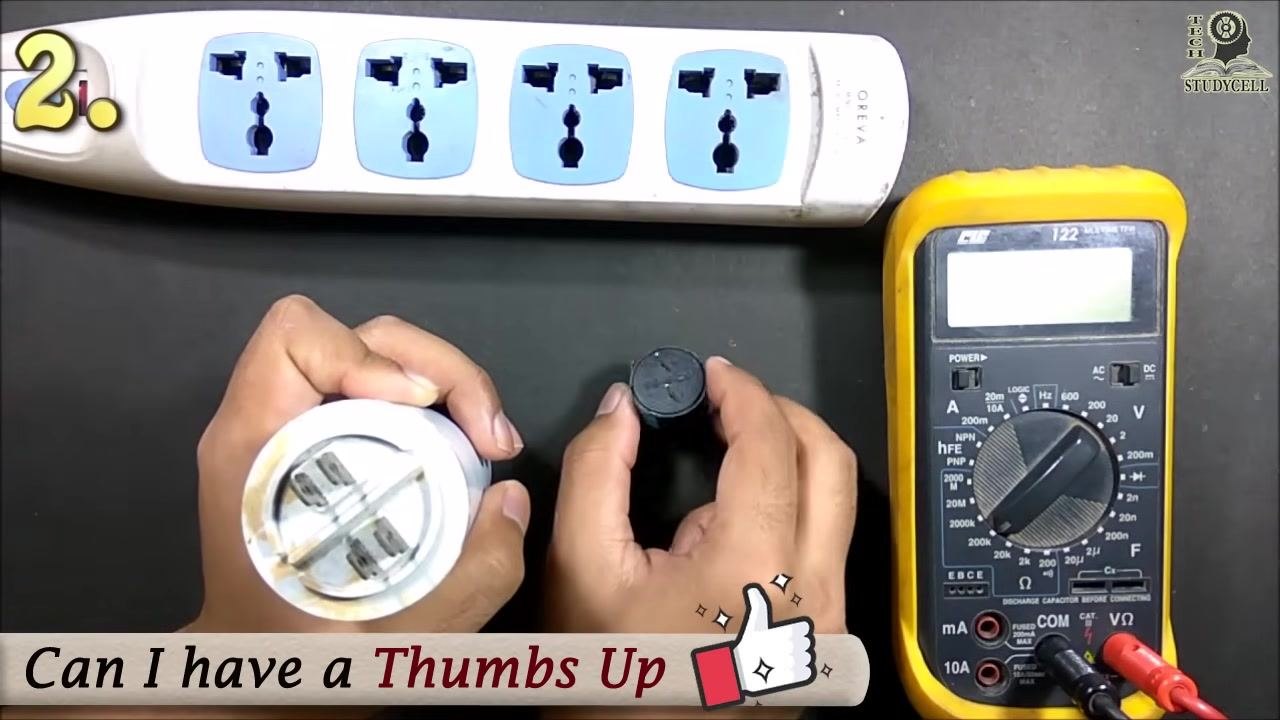 The user holding the capacitor and buzzer after the test, confirming the buzzer sounded and the capacitor is functional