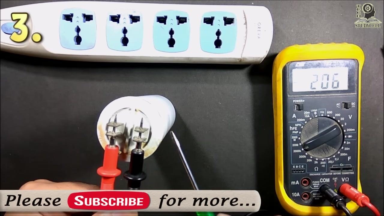 Both probes connected to the capacitor with the multimeter showing "206" and a hand holding a screwdriver nearby