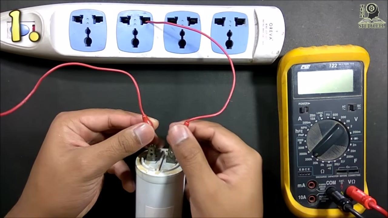 Both wires connected to the capacitor, with the free ends about to be connected to the power strip to charge the capacitor
