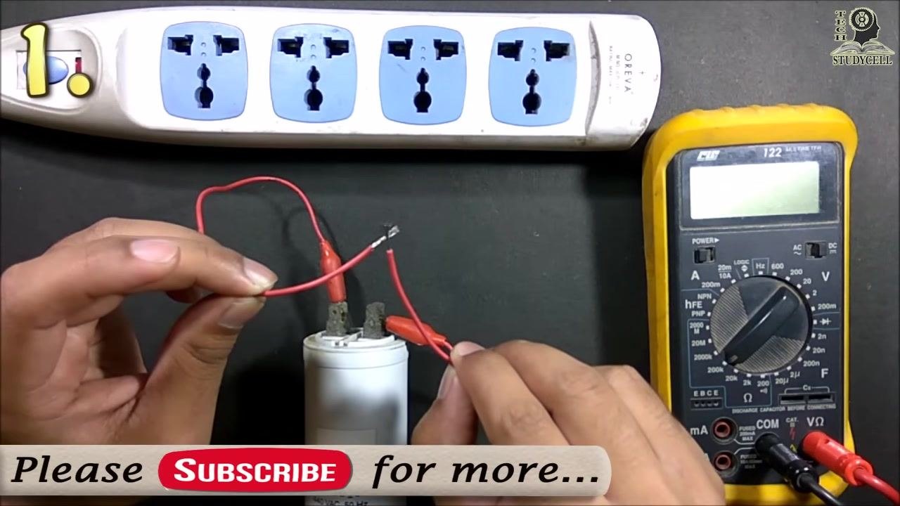 The user holding the two wires, preparing to short them together to discharge the capacitor