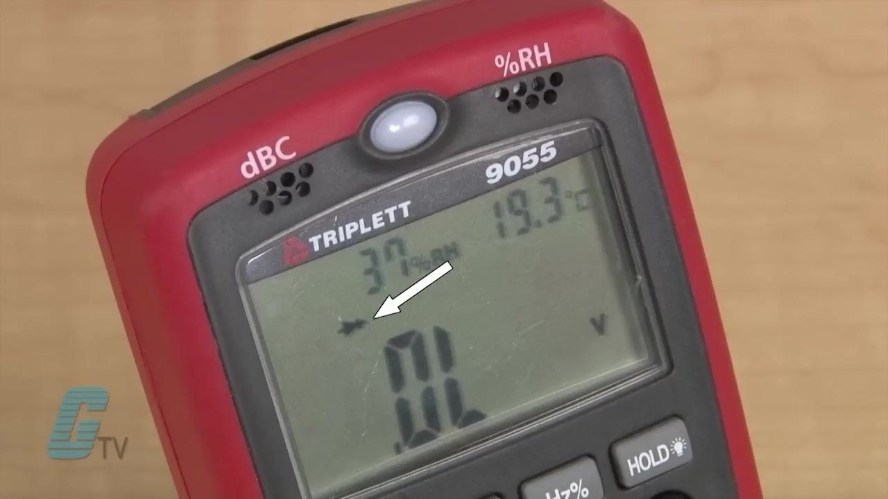Close-up of a TRIPLETT 9055 digital multimeter display showing the "OL" reading, the radio wave symbol, and an arrow pointing to a specific icon.