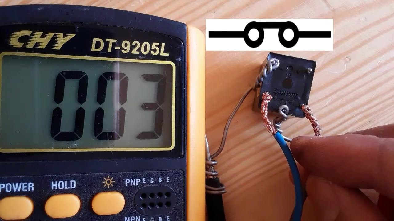Multimeter display shows "003" (very low resistance) with a relay switch schematic overlay and terminals connected