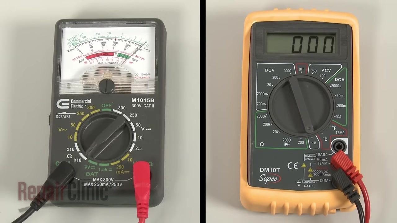 Thermostat with disconnected wires, multimeter probe positioned near the left-side terminals, insulation and warning label visible