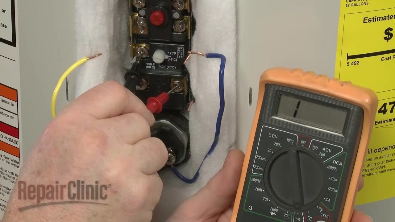 Digital multimeter showing "1" (no continuity) while probes are placed on the lower thermostat terminals, with exposed insulation and visible wiring