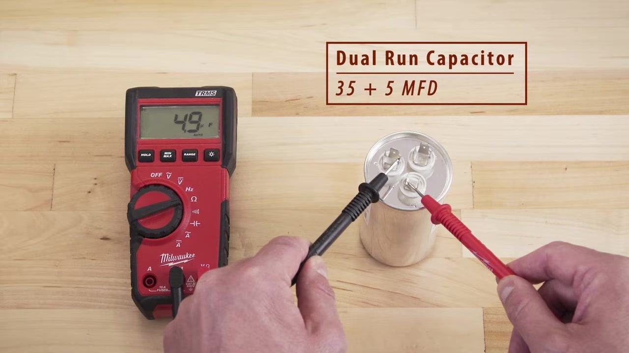 Multimeter showing 4.9 μF while testing between the Fan and Common terminals on a dual run capacitor labeled 35 + 5 MFD