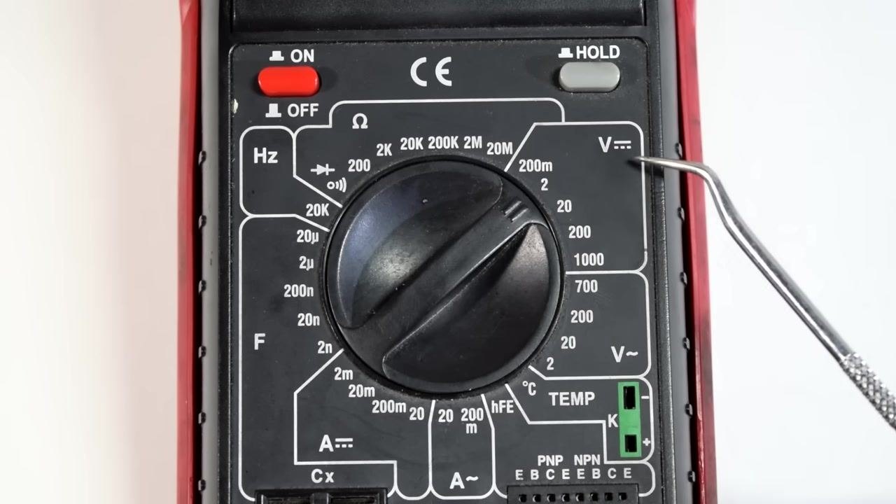 A metal pointer indicates the 2V setting on the DC voltage scale of the multimeter dial.