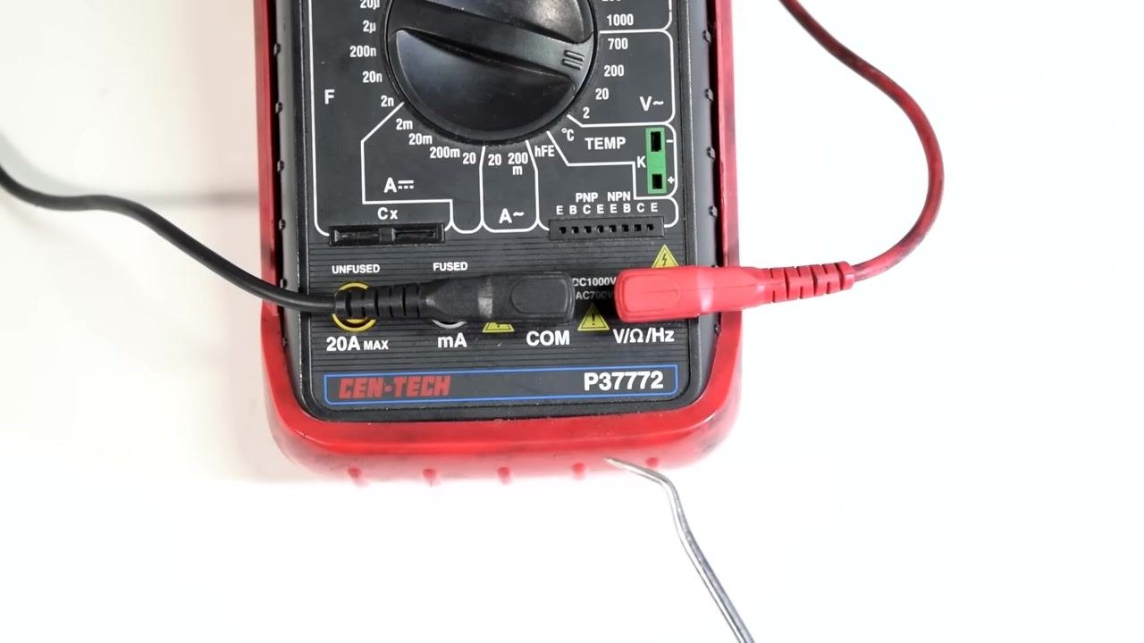 A digital multimeter (CEN-TECH P37772) with black and red test leads connected to the COM and V/Ω/Hz ports, dial set to the resistance section, on a clean white background.