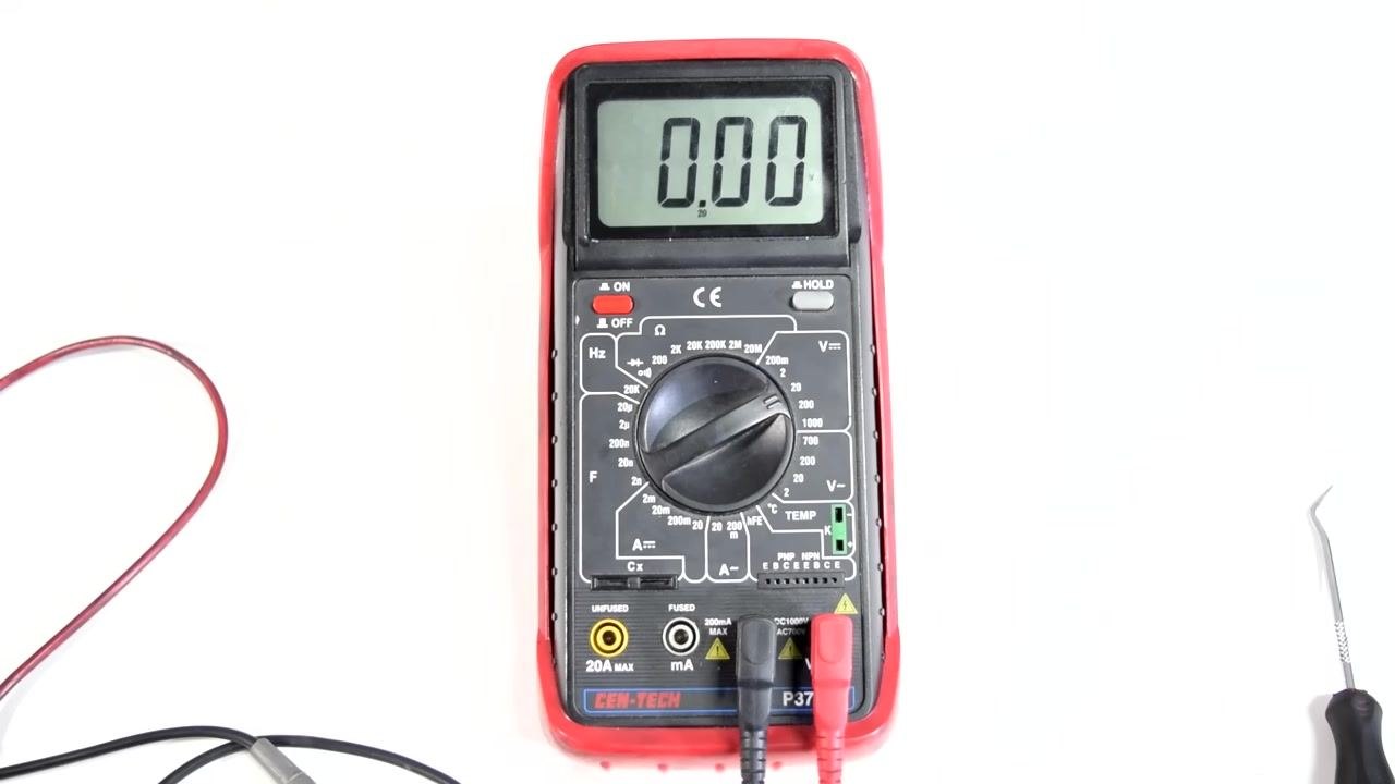A digital multimeter displays 1.614, with the black test lead on the positive terminal and the red test lead on the negative terminal of an AA battery, showing a reversed connection.